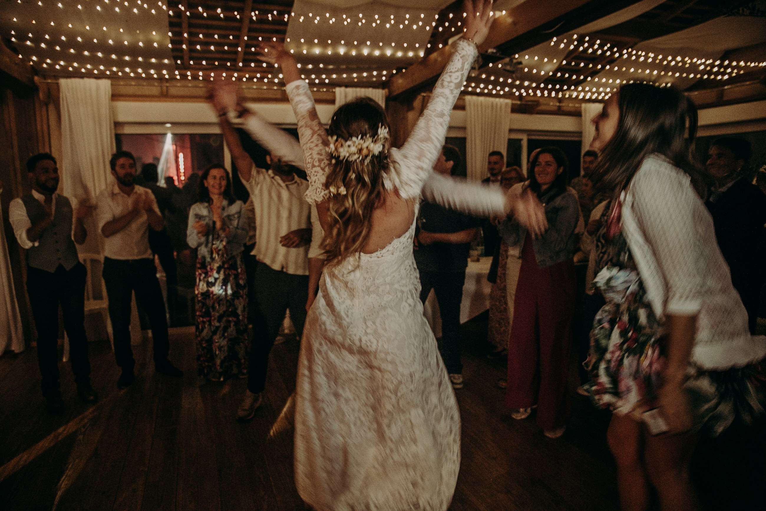 La mariée danse avec ses invités sous les guirlandes