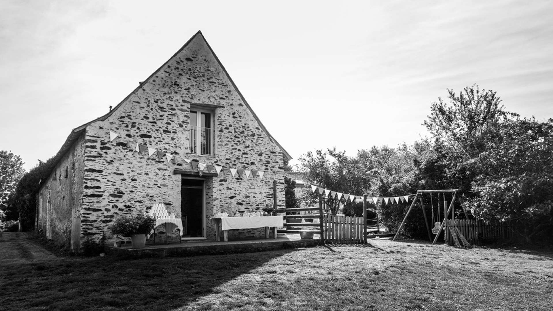 La grange en pierre et ses fanions, en noir et blanc